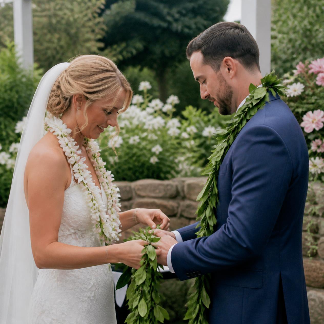 A couple wearing flower and leaf leis during their wedding ceremony